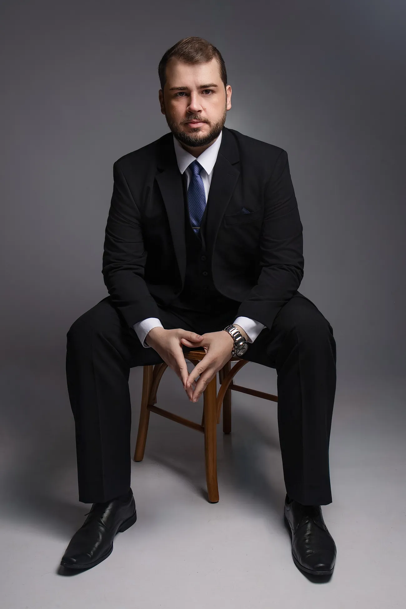 Gabriel Selbach, advogado, de terno escuro e gravata azul, com as mãos entrelaçadas